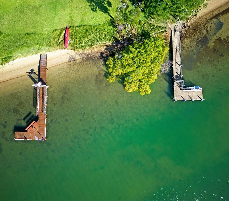 Birds-eye aerial view focusing directly on Cayman Quays' private guest jetty and secure boat mooring facilities on the Noosa River.