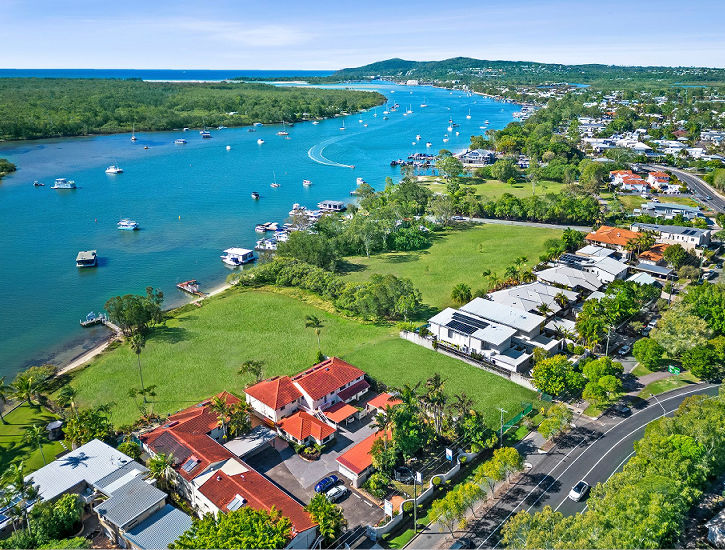 Aerial drone view of the Noosa River looking down on the waterfront holiday apartments at Cayman Quays property in Noosaville.