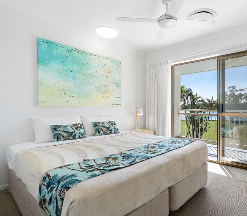 Comfortable and beautifully styled townhouse bedroom configured with two single twin beds and large windows offering bright, natural light.