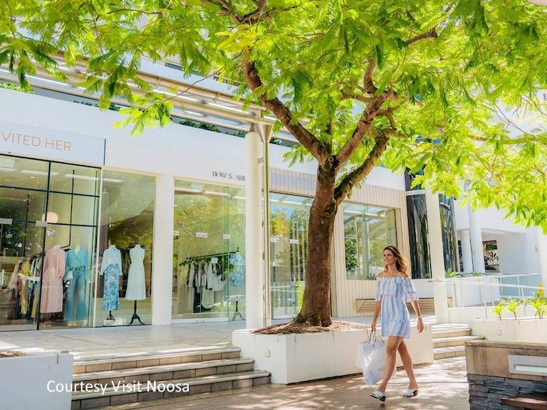 Visitors browsing premium 5-star fashion boutiques and retail shops along the iconic Hastings Street strip in Noosa Heads.