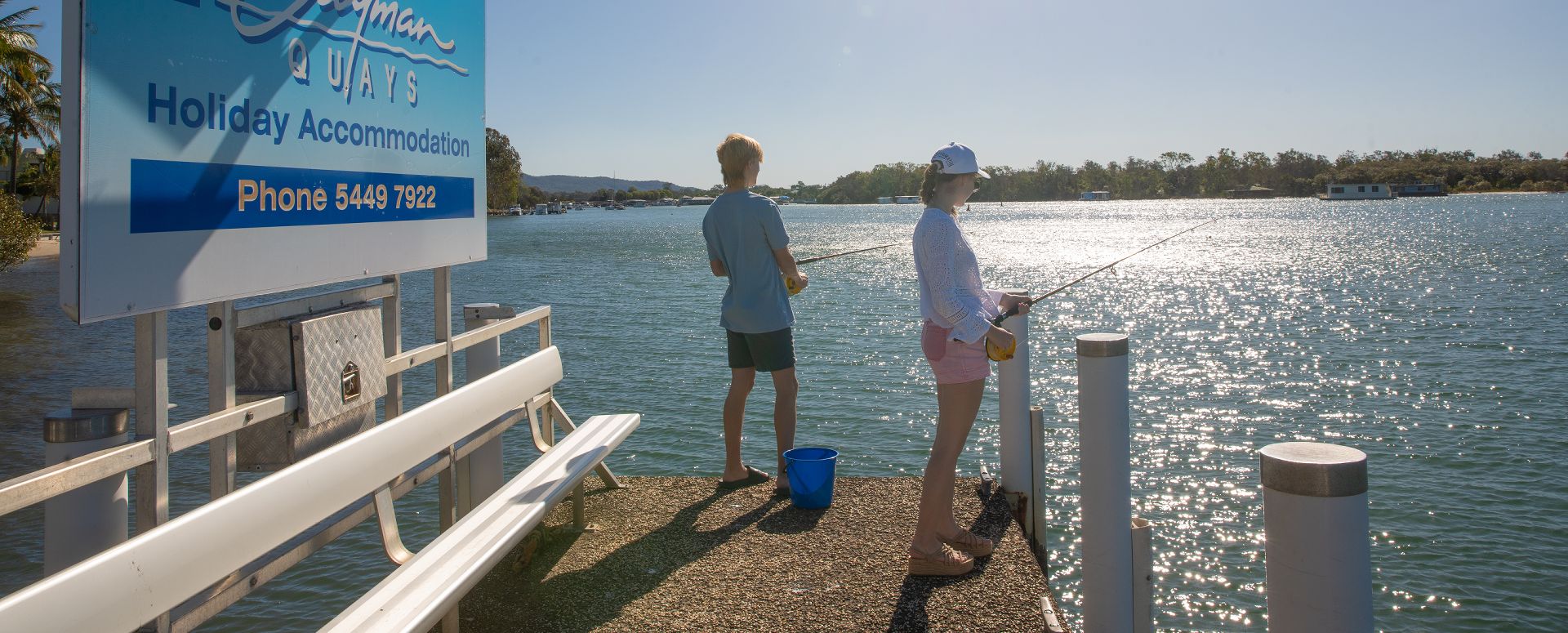 Guests enjoying complimentary fishing rod hire from the private jetty at Cayman Quays self-contained apartments on the Noosa River.
